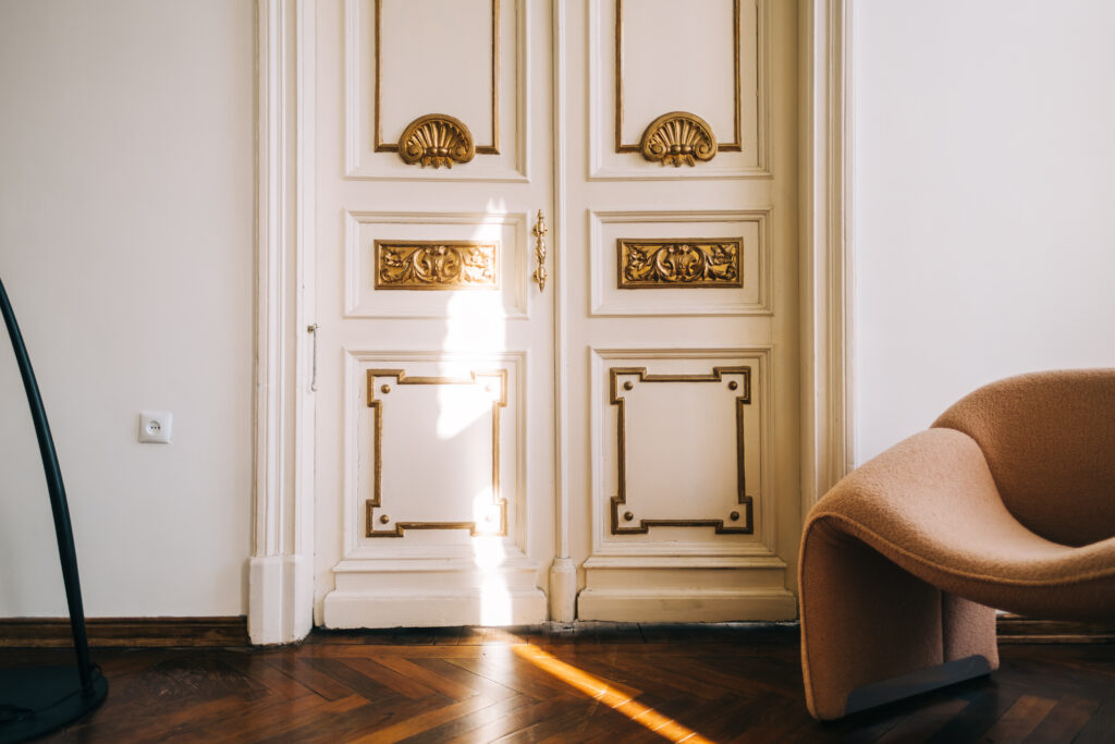 Beautiful ornamental vintage door installation in bright living room, interior details.