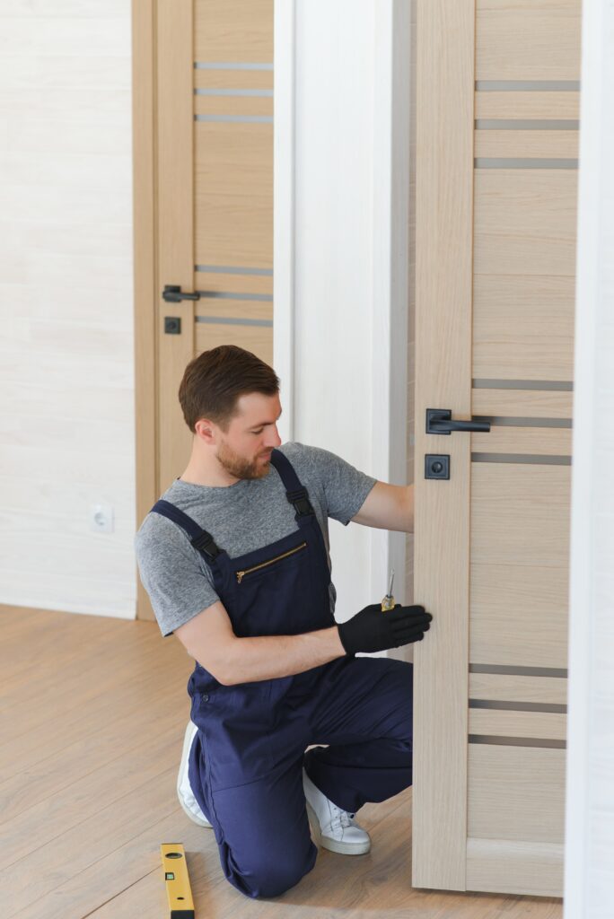 Young man installing the door in house.